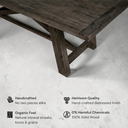 Wooden table with distressed finish on a concrete floor, featuring text about its qualities.