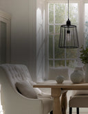 Modern living room with white armchair, wooden table, and large window.